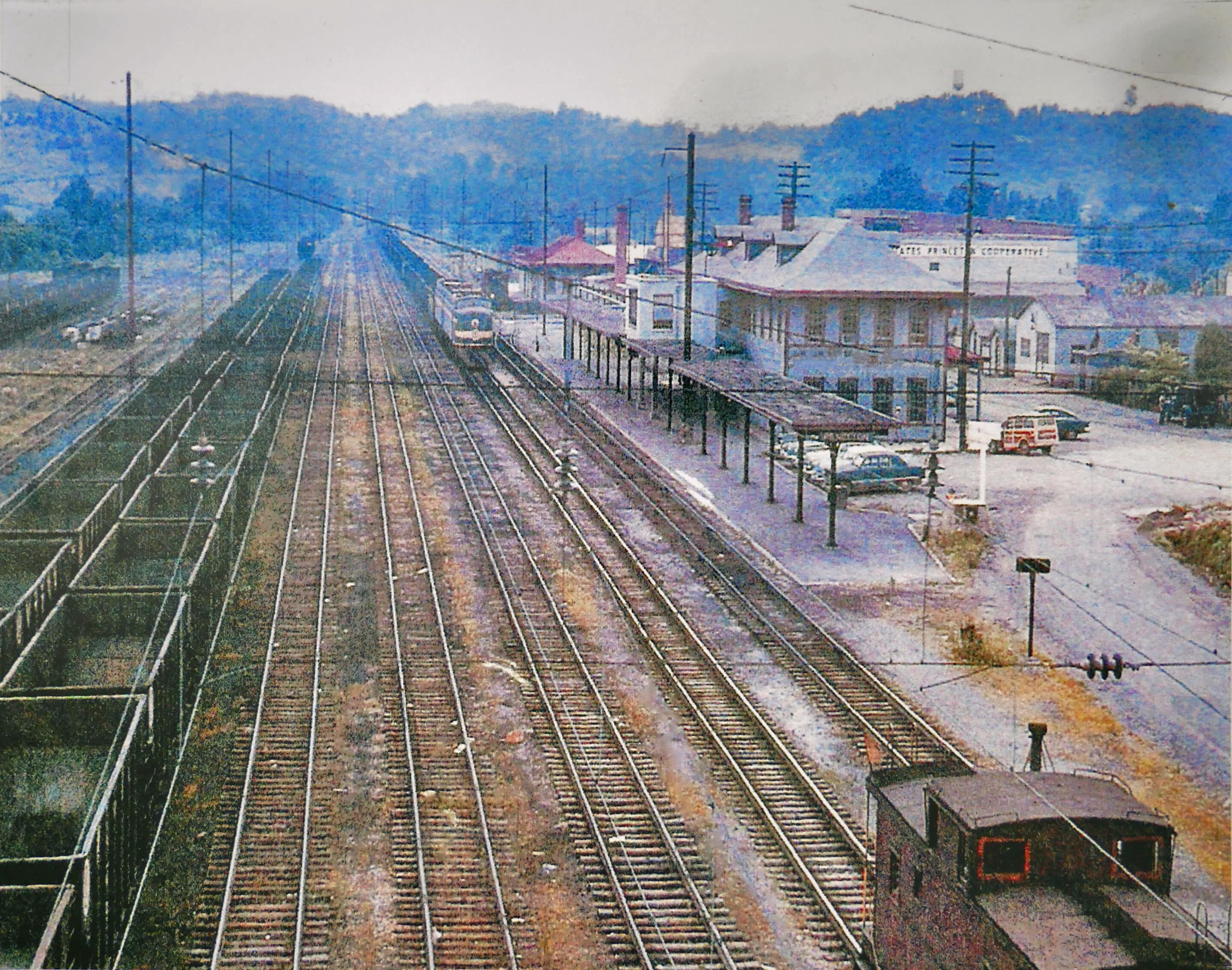 A historic photo of the Princeton railroad station with railroad shops along the tracks.